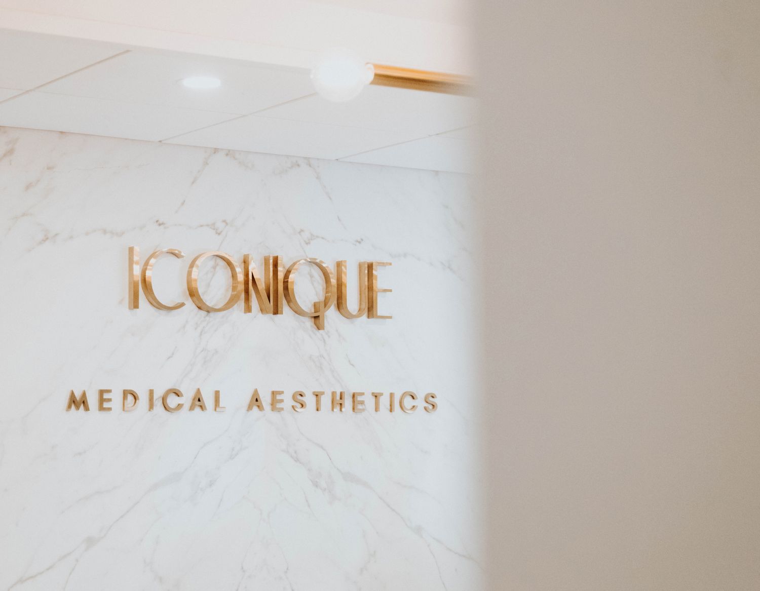 Iconique Medical Aesthetics logo on wall.